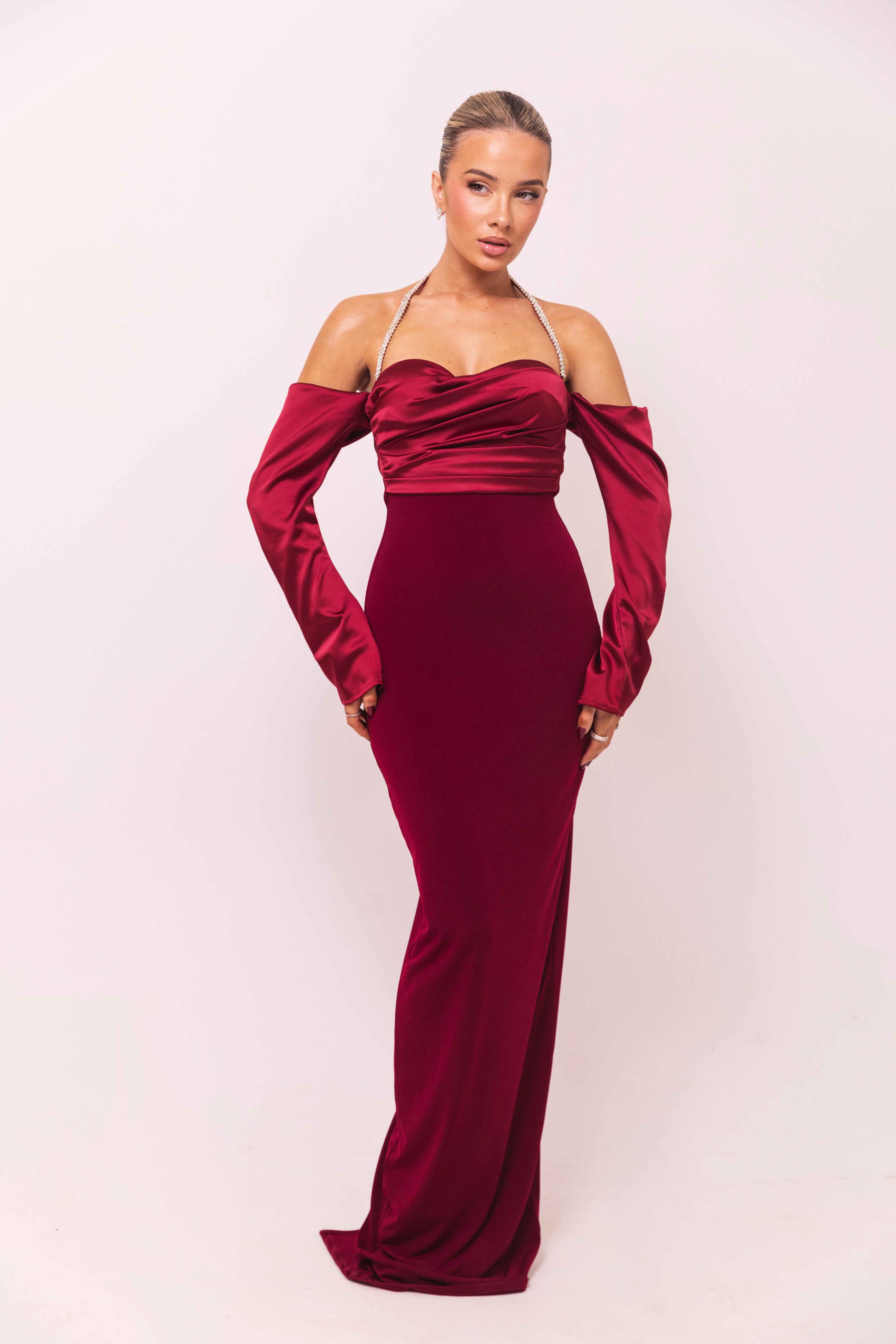 Sophisticated burgundy evening gown featuring a draped satin design and fitted silhouette.