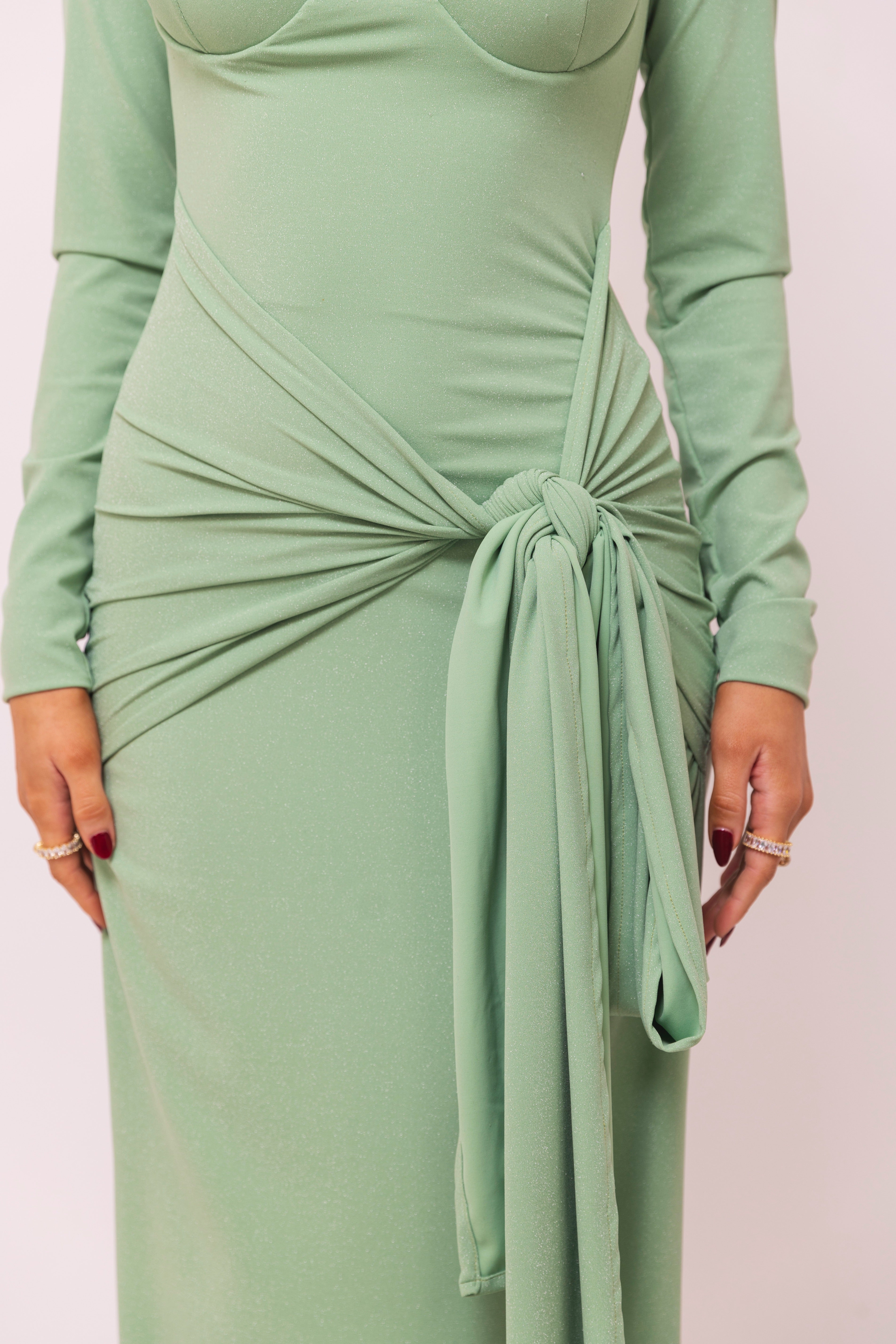 Green dress with a sweetheart neckline, a knotted waist, and a sleek silhouette.