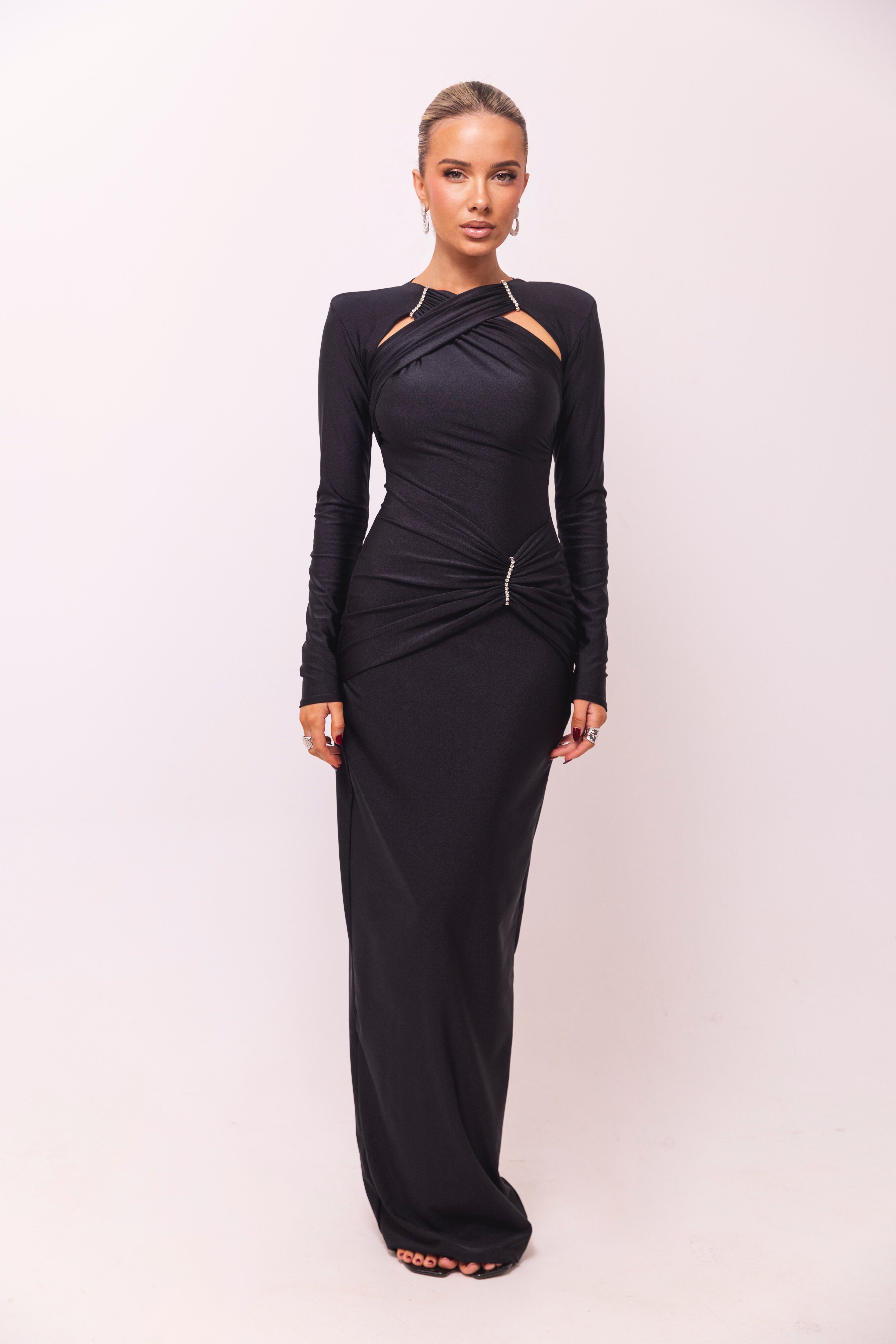 Black gown with long sleeves and delicate draped detailing for an elegant look.