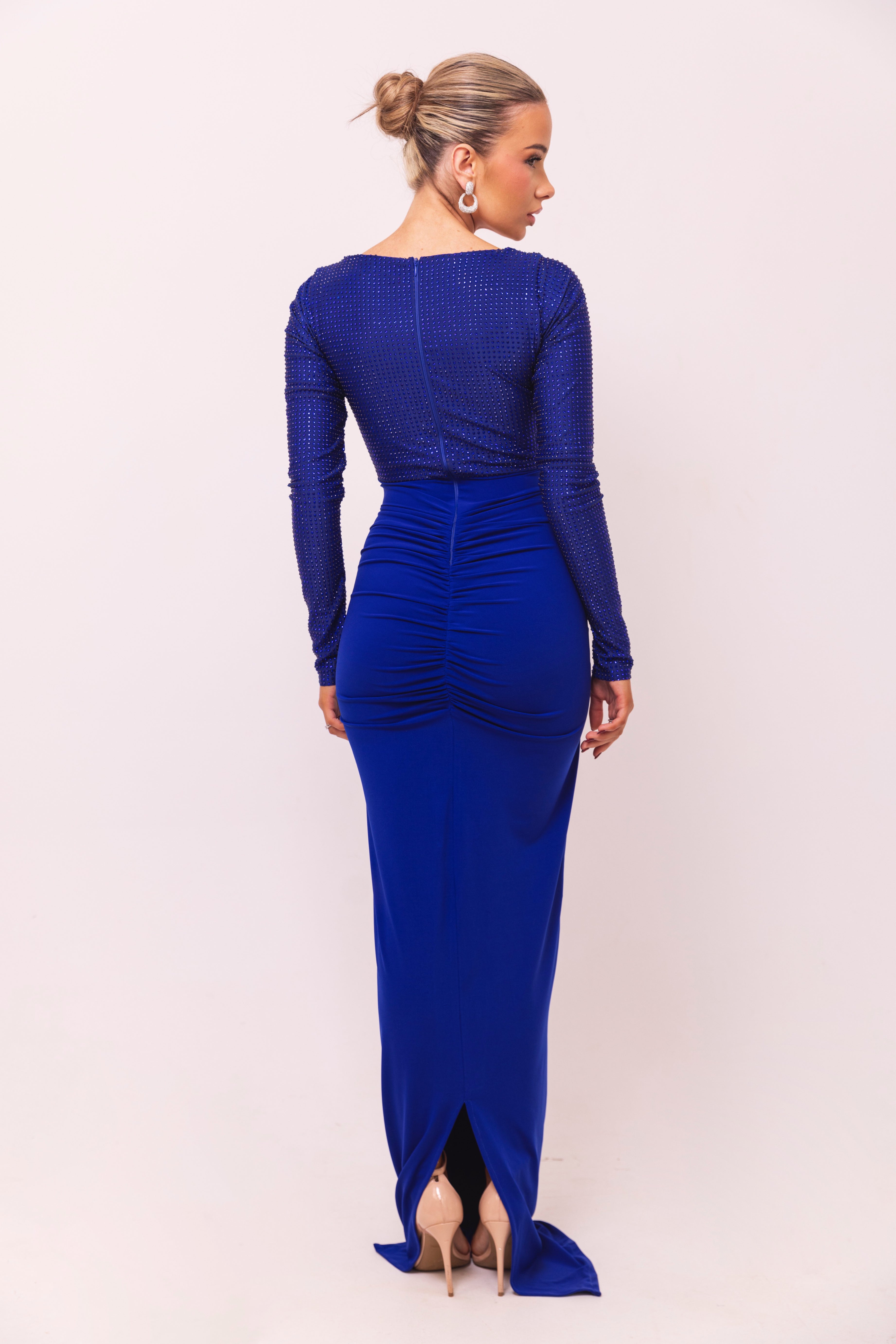 Royal blue dress with long sleeves, a sweetheart neckline, rhinestone embellishments, and a knotted draped skirt.