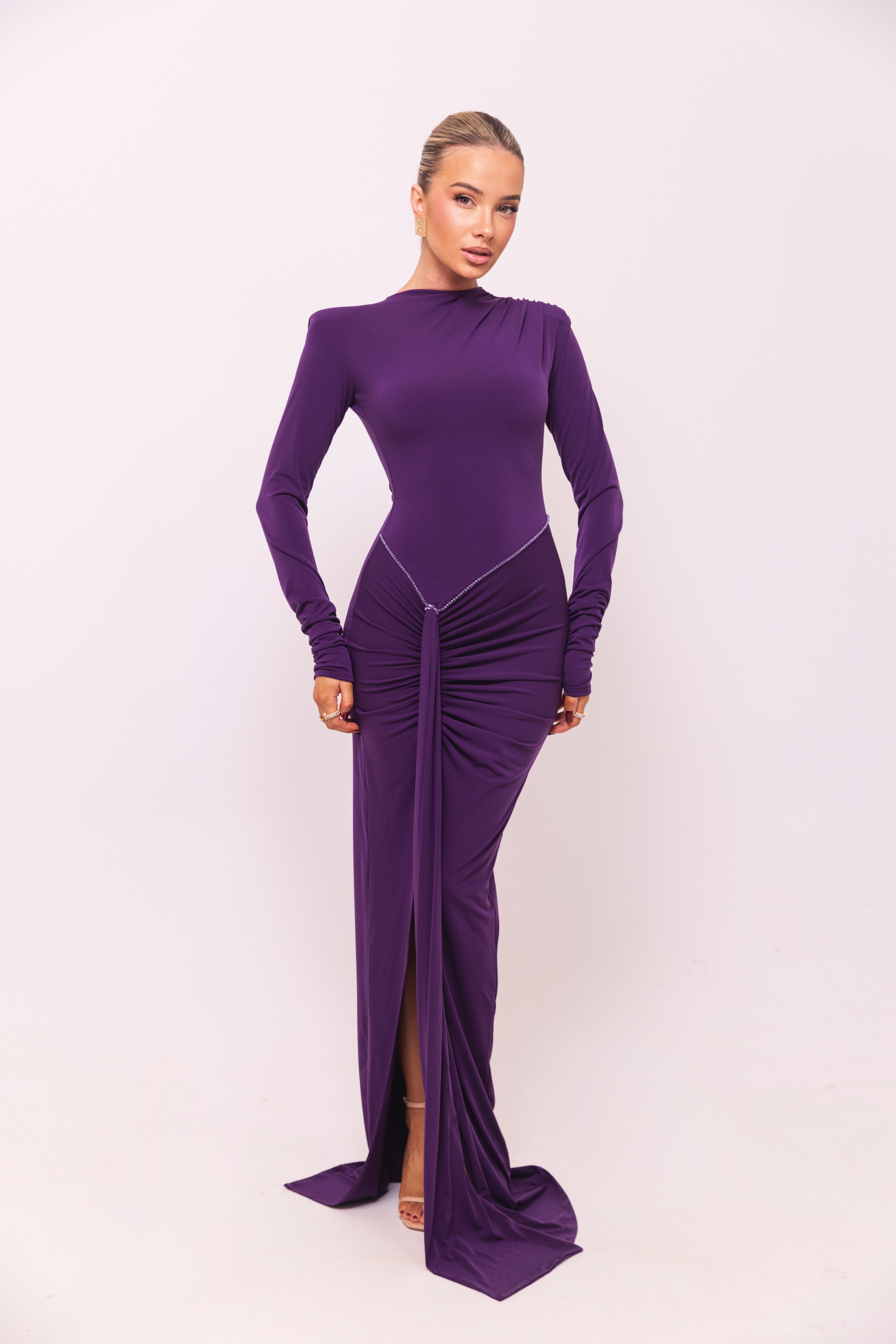 Fitted purple dress with long sleeves and subtle rhinestone detailing at the waist.