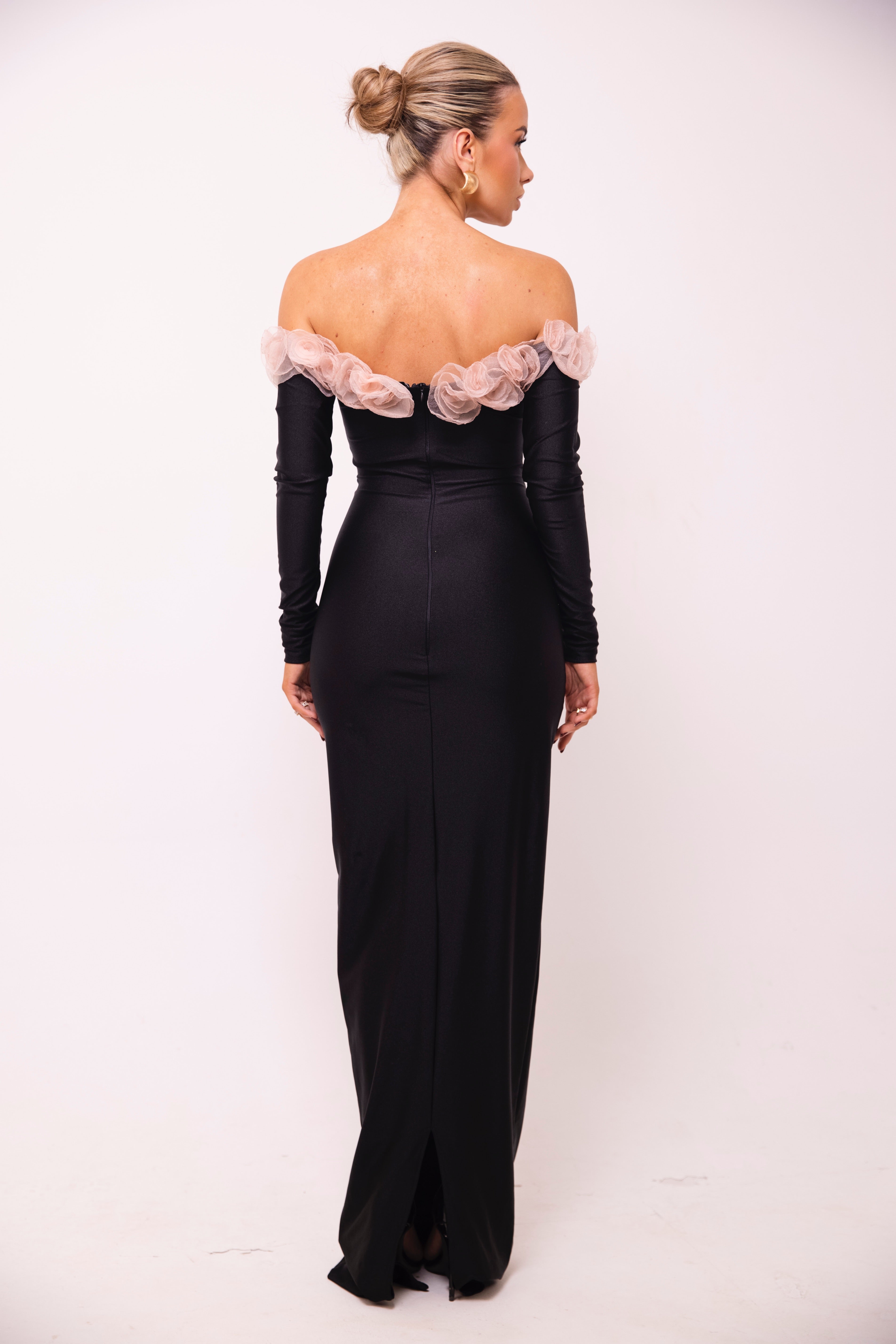 Chic black evening dress with long sleeves and a romantic floral neckline detail.